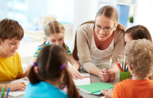 Teacher sitting at a table with students