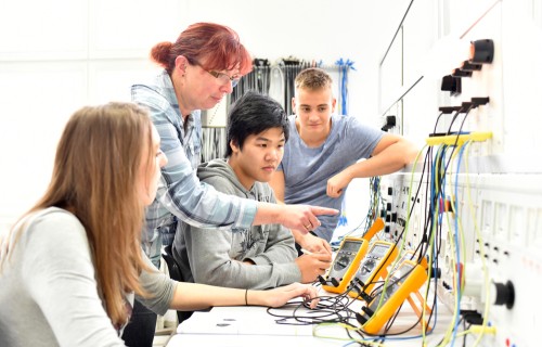 Students work on electronics with teacher