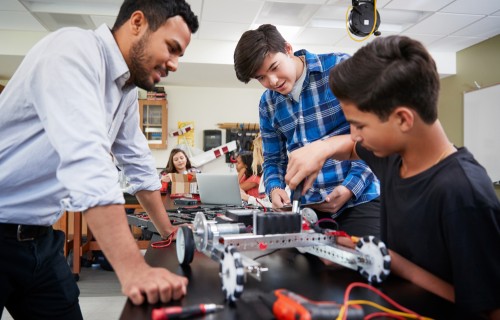 Students work on electronics with teacher