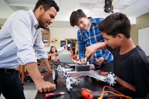 Students work on electronics with teacher