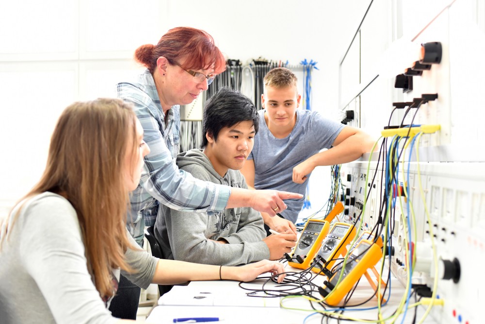 Students work on electronics with teacher